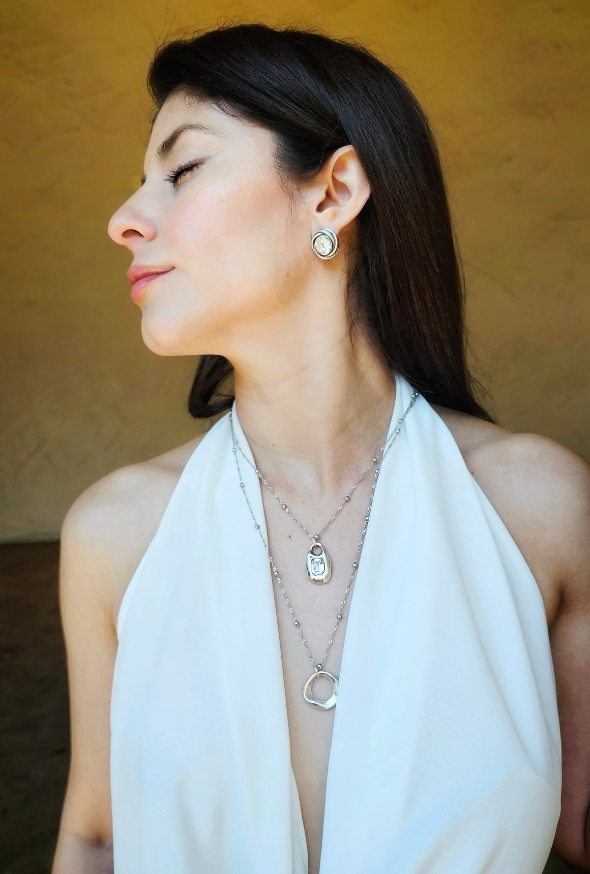 Crystal Aura Necklace: model wearing a layered silver-tone crystal necklace.