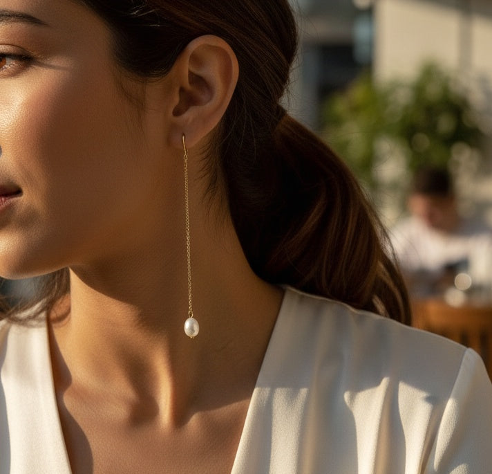 La Perle Line Earrings: model wearing long pearl-accent drop earrings, side view.