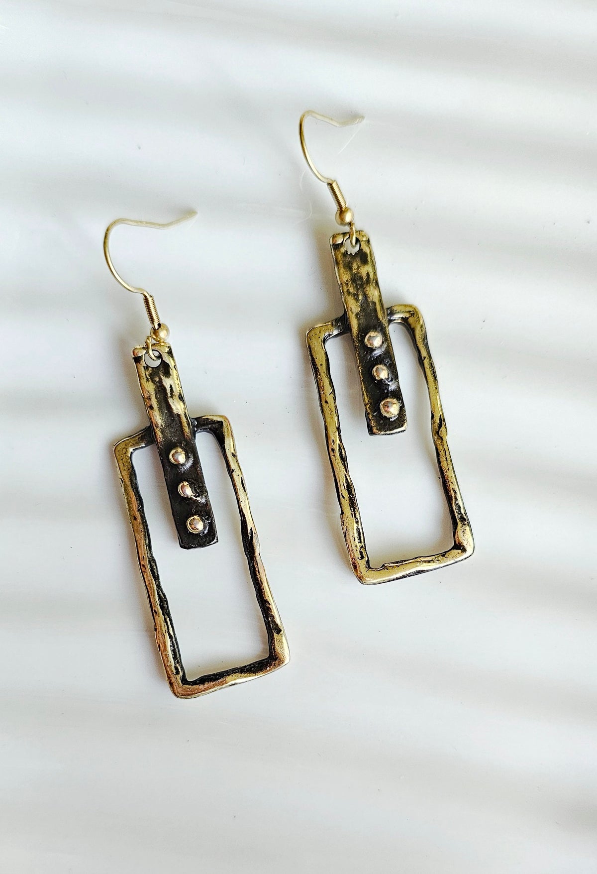 Linear Earrings: slim rectangular drop earrings with hook closures, close-up.
