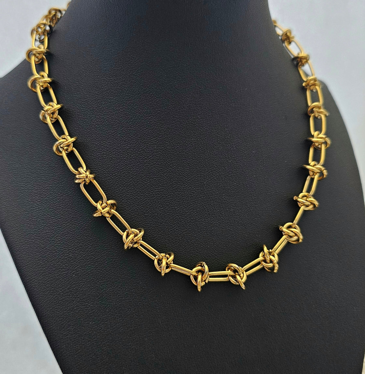 Luxe Knot Necklace: gold-tone knot-link necklace showing linked knot details.