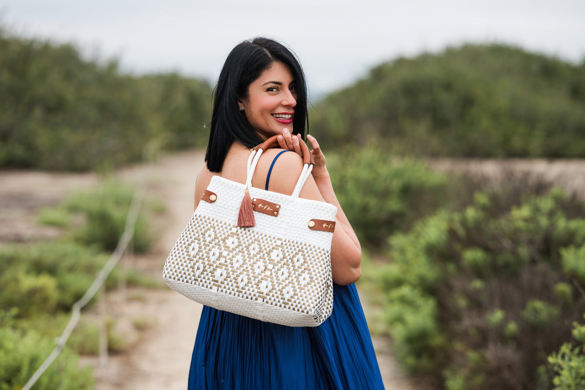 MAVIS BY HERRERA Digital Gift Card: woman carrying an ivory woven handbag with brown leather handles.