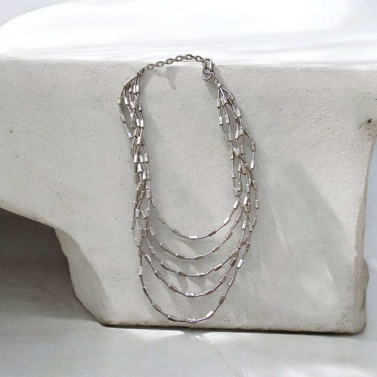 Venetian Tiers Necklace: layered silver-tone chain necklace on a display bust.