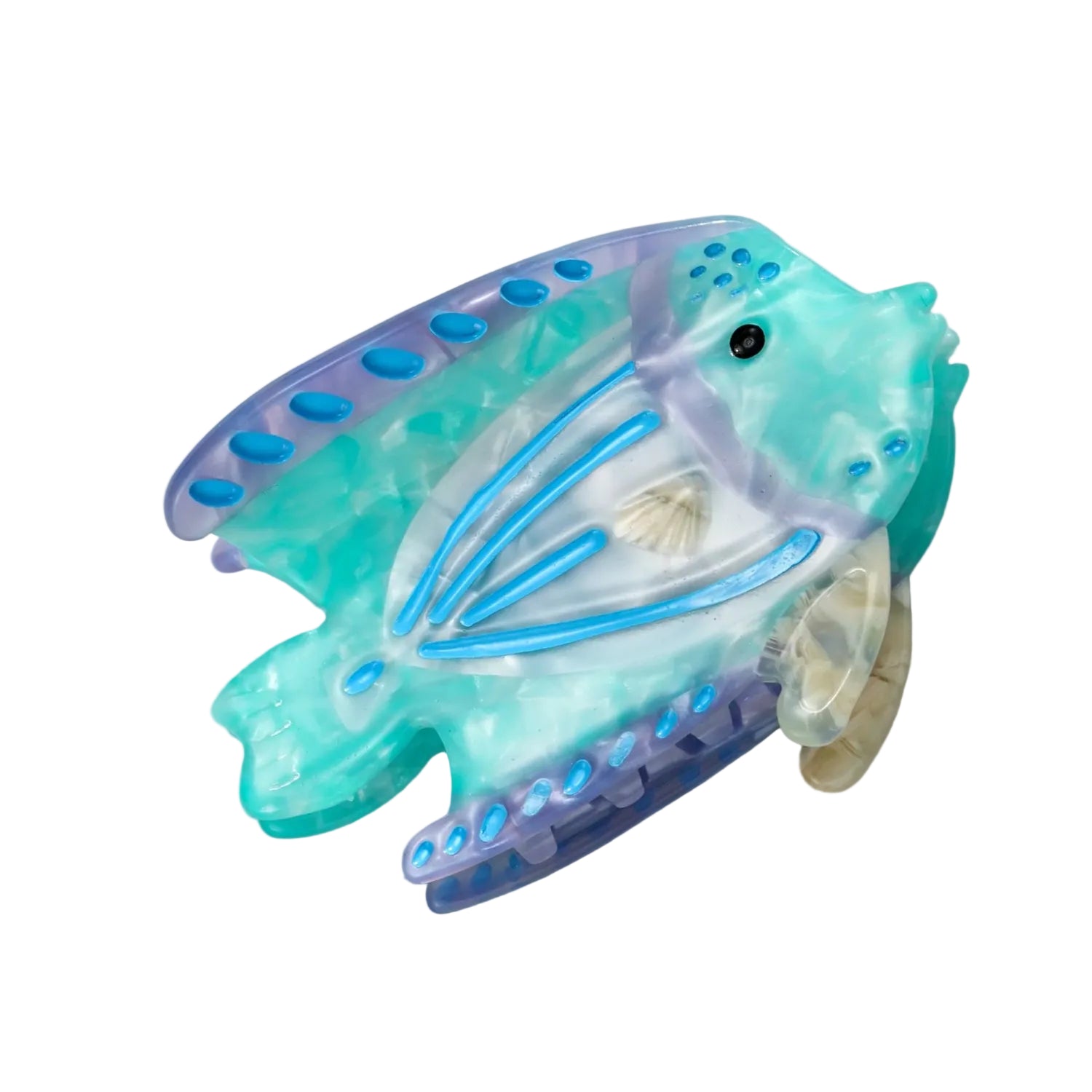 A translucent fish-shaped hair claw clip in marbled aqua, teal, and lavender purple, featuring blue details and a small seashell accent, displayed on a white marble surface.