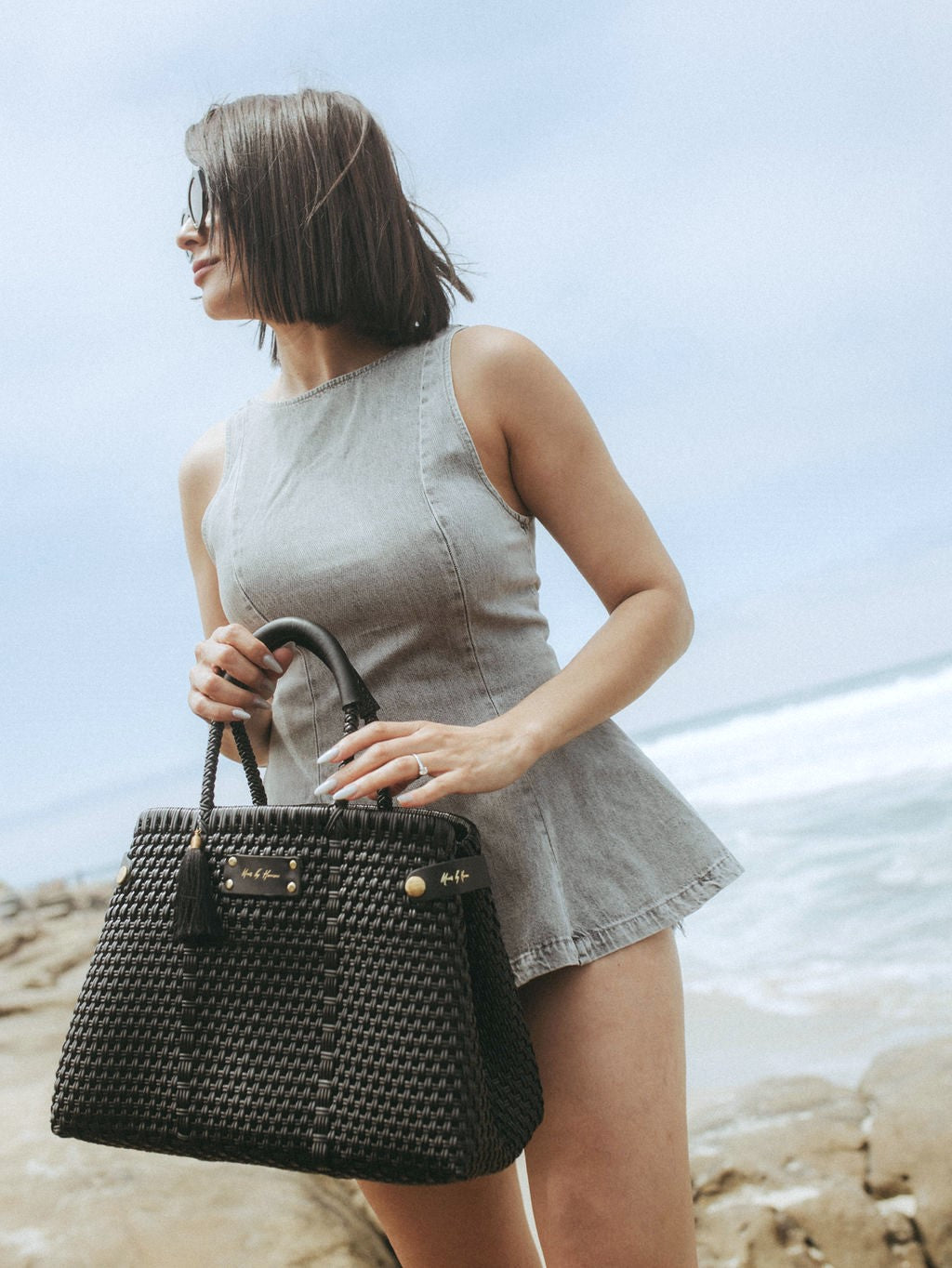 A luxury handbag in black, sustainably crafted from ethically sourced and recycled plastic and leather.