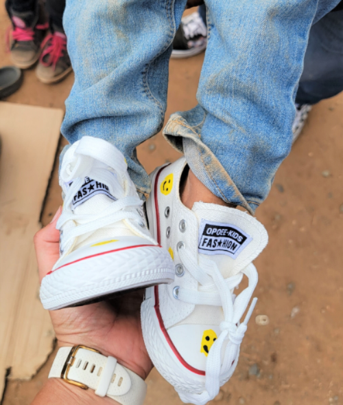 Founder Mavis Carolina Herrera giving a pair of shoes to a kid in need