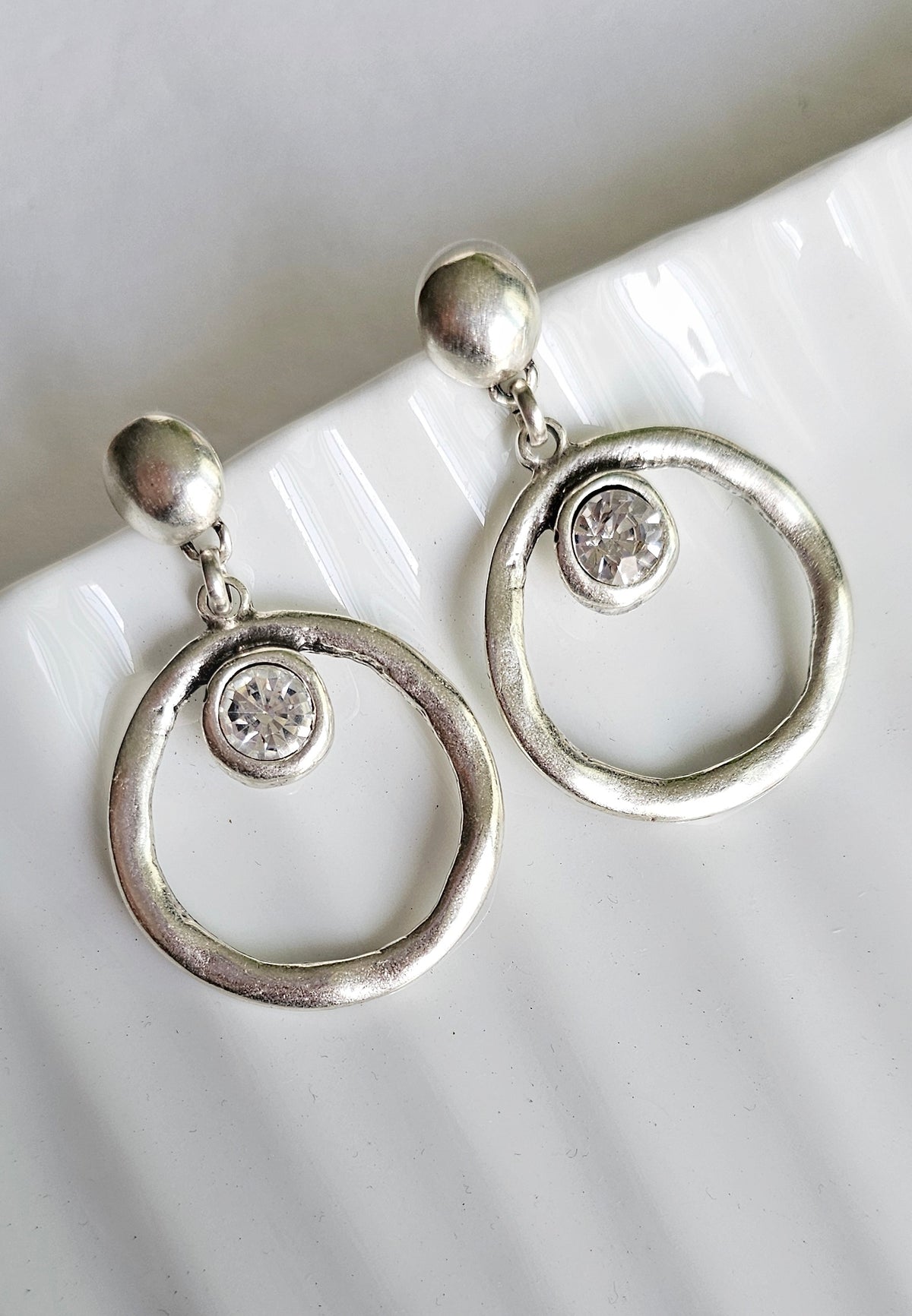 Infinity Crystal Earrings Hoops: silver-tone circular drop earrings with crystal accents.