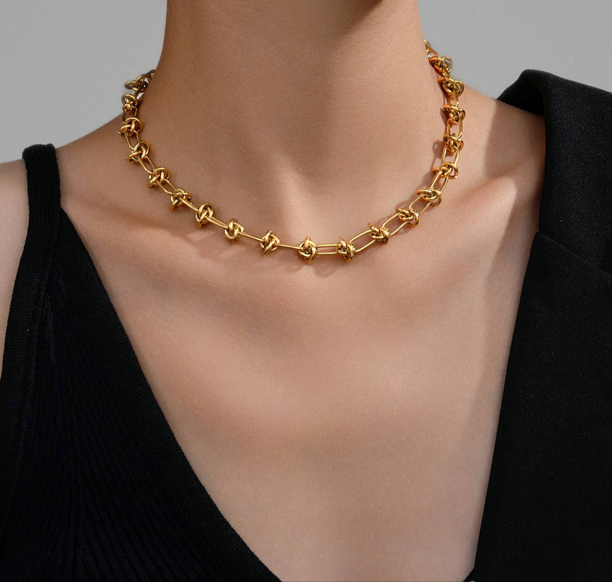 Luxe Knot Necklace: model wearing a gold-tone knot-link necklace.