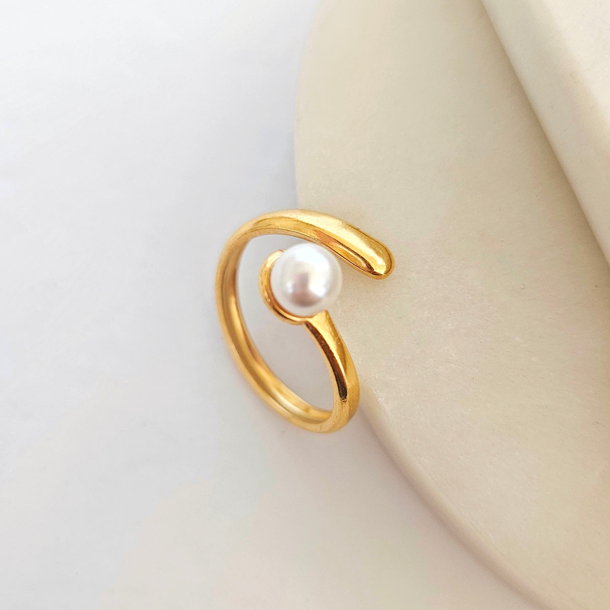 The Pearl Adjustable Ring: gold-tone adjustable open ring with pearl accent.